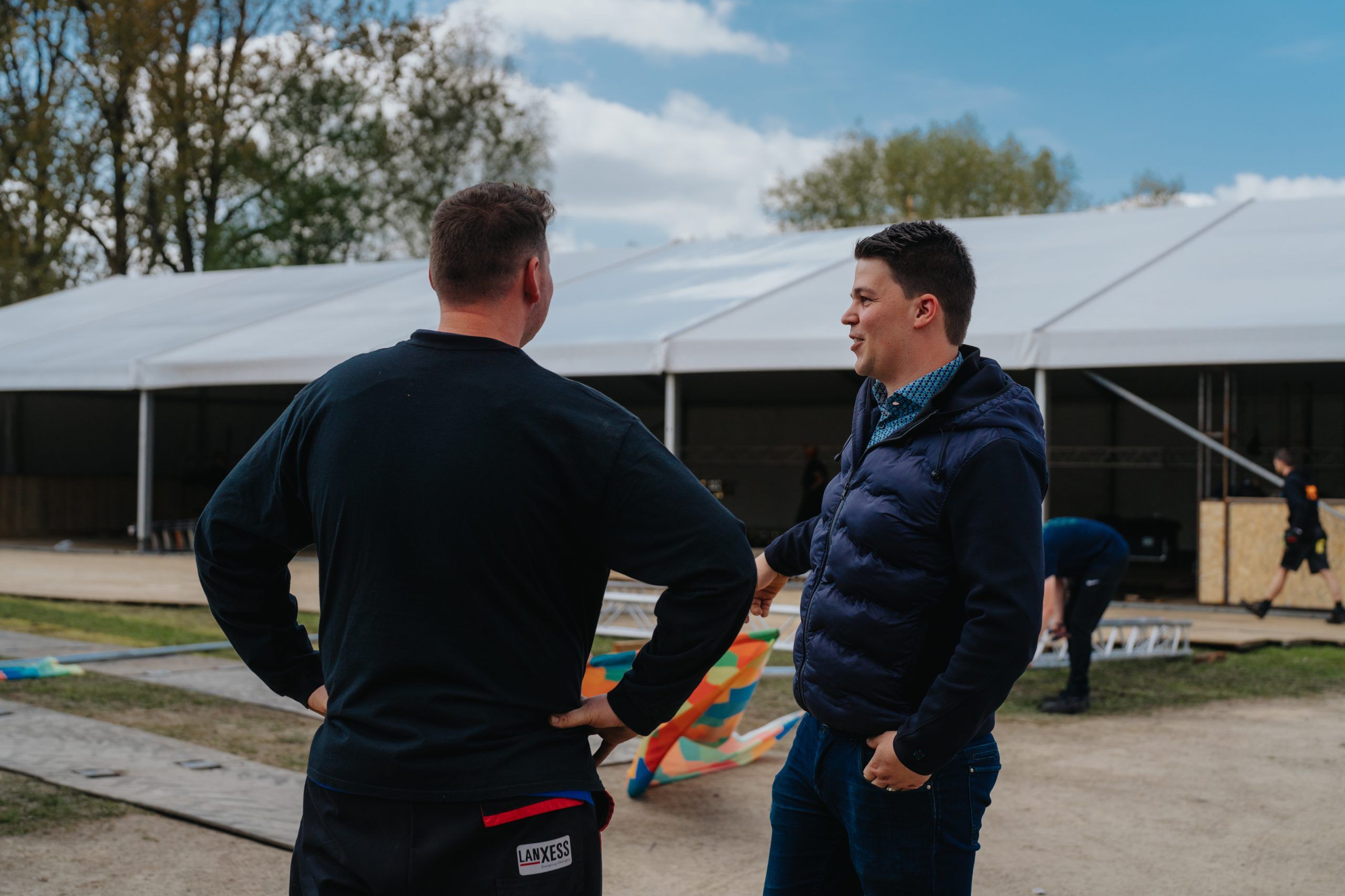 Twee medewerkers bespreken de inrichting van een evenemententent.