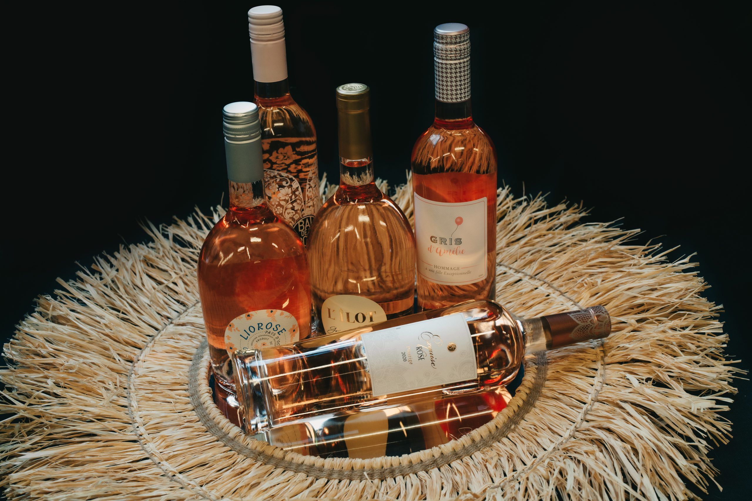 Selectie van roséwijnen op een decoratieve strooien ondergrond.