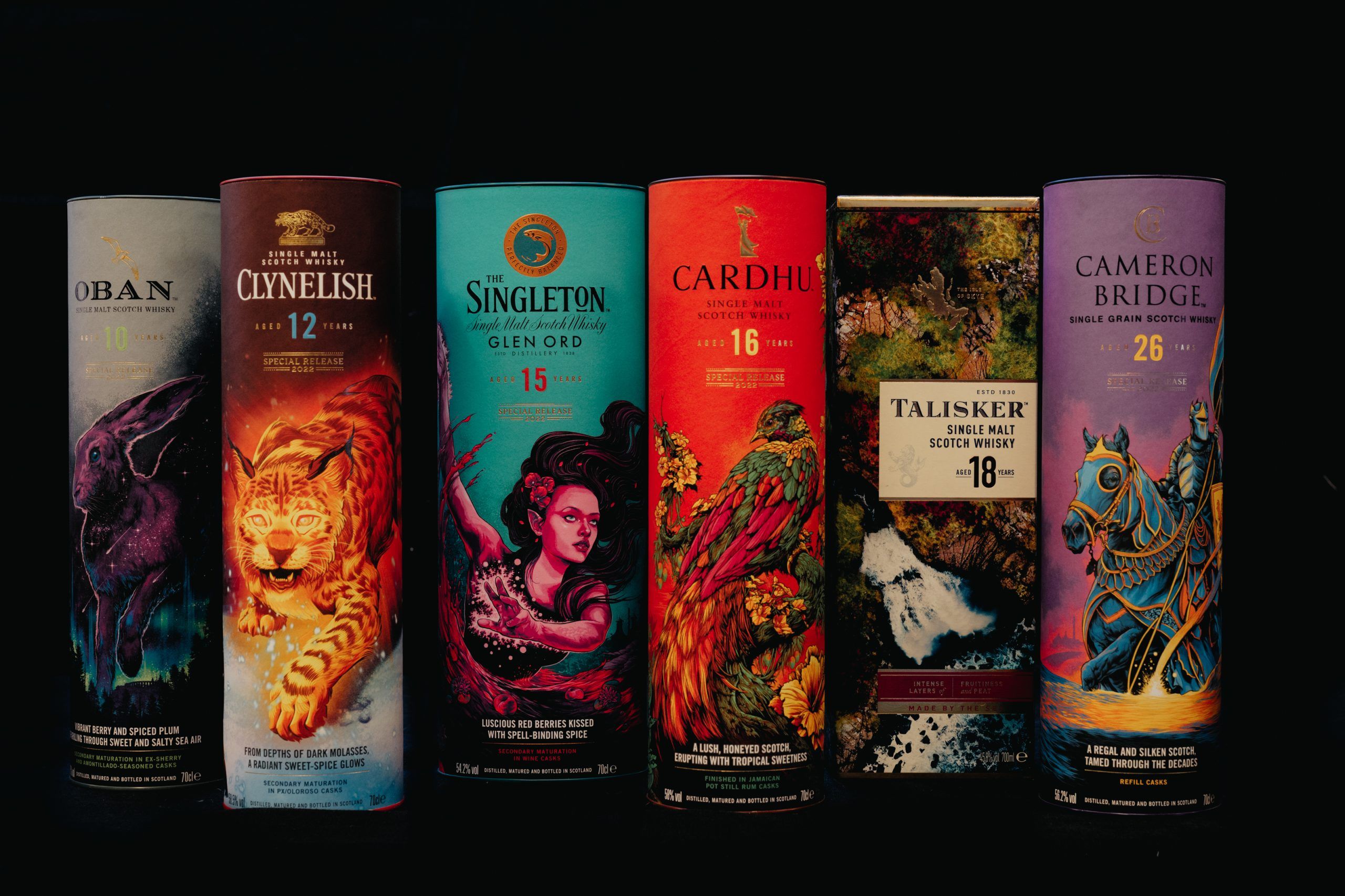 Zes flessen single malt whisky in kleurrijke verpakkingen, waaronder Oban, Cardhu en Talisker.