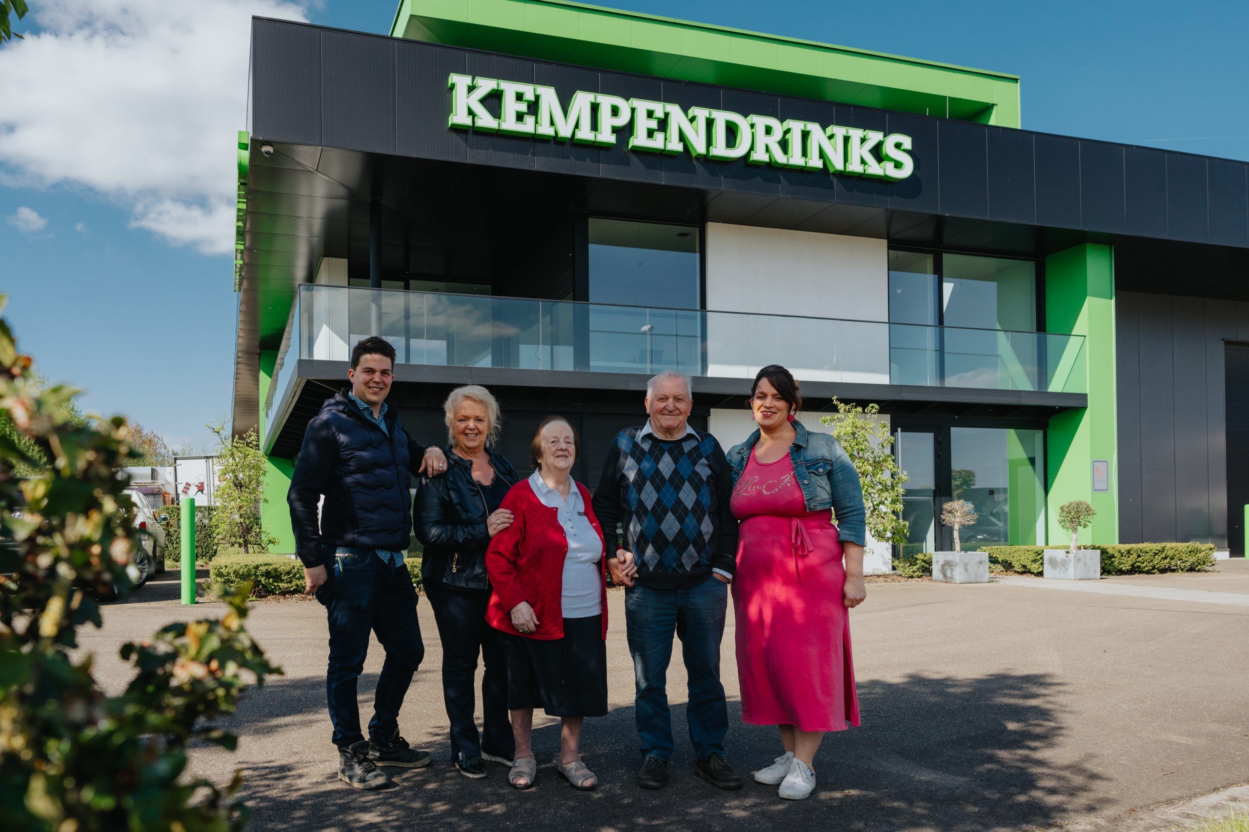 Groepsfoto van familieleden voor de gevel van Kempendrinks.