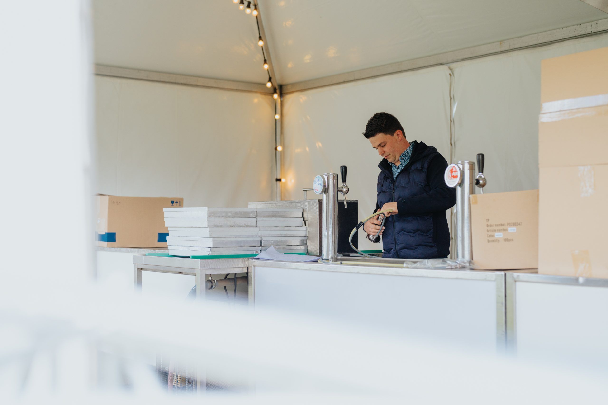 Medewerker test een biertapinstallatie tijdens de opbouw van een festival.