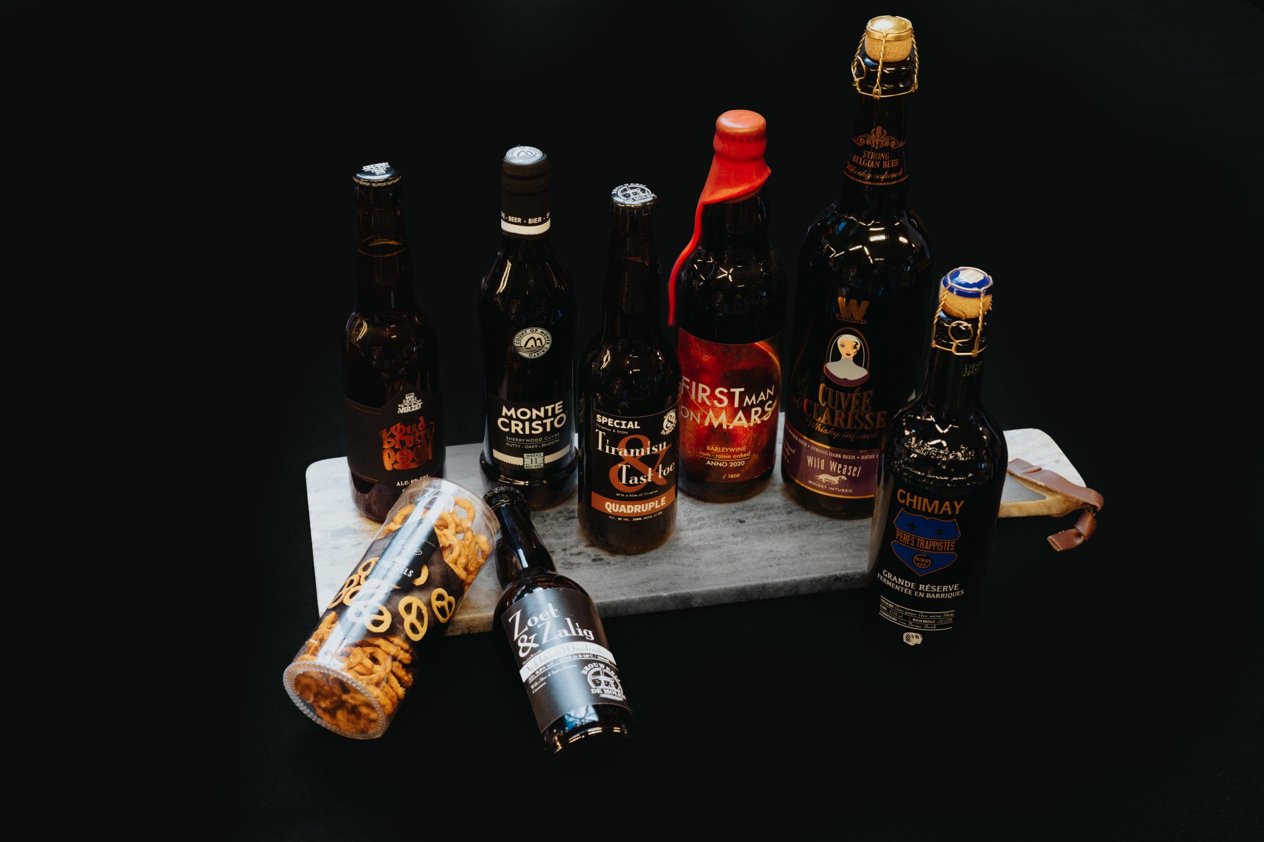 Cadeaupakket met twee flessen wijn, chips, dips en chocolade.